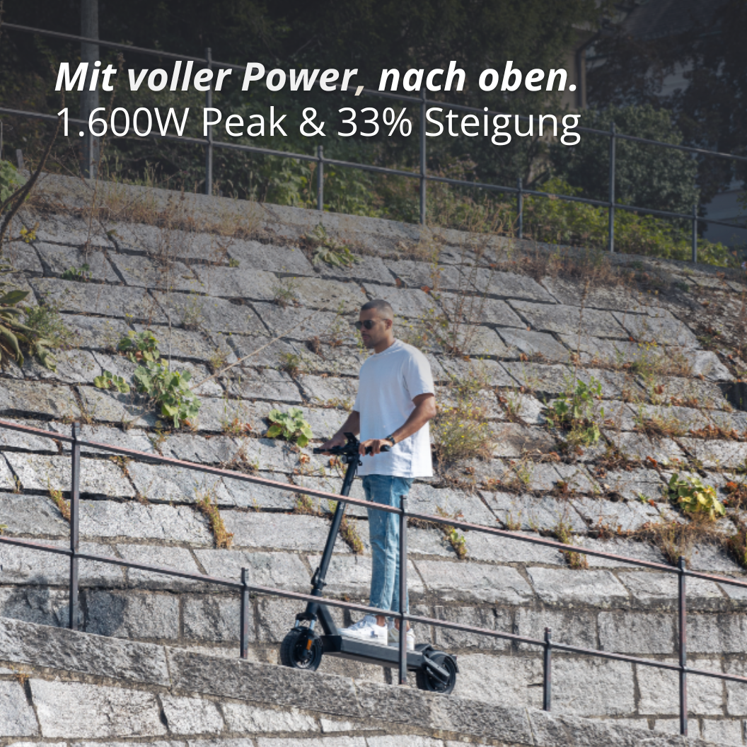 Mann fährt auf E-Scooter Steigung hoch